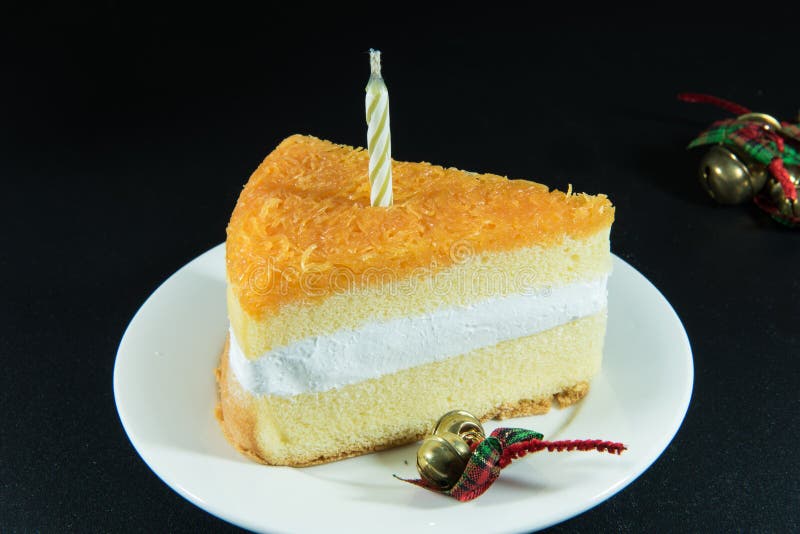 Gold Threads Cake and Bell Decoration and Candle on Texture Black Stock