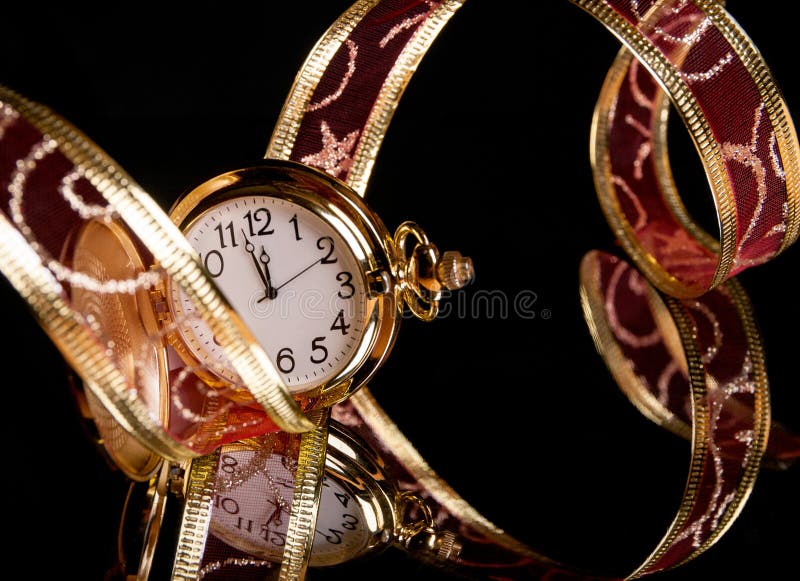 Gold watch and a red delicate ribbon on a black
