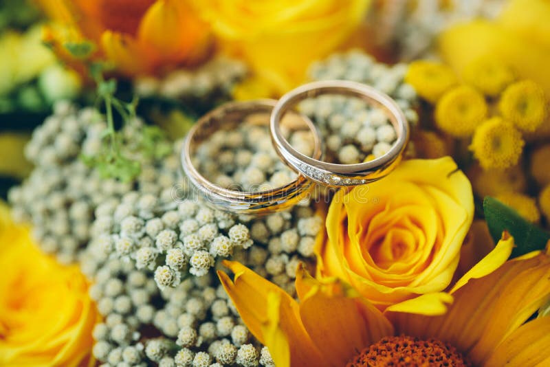 Gold wedding rings on the yellow bride bouquet.Declaration of lo