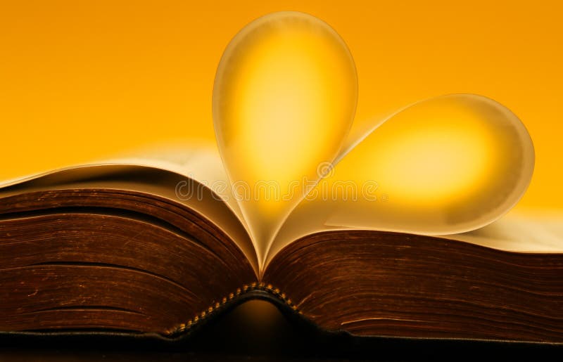 Gold, yellow glowing pages of a bible forming a heart royalty free stock image Gold, yellow glowing pages of a bible forming a heart royalty free stock image