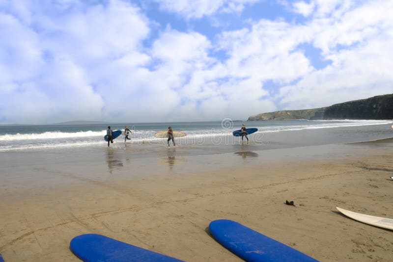 Golden beach with children going to surf