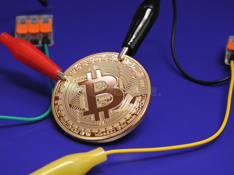 Golden Bitcoin with alligator clips royalty free stock photos