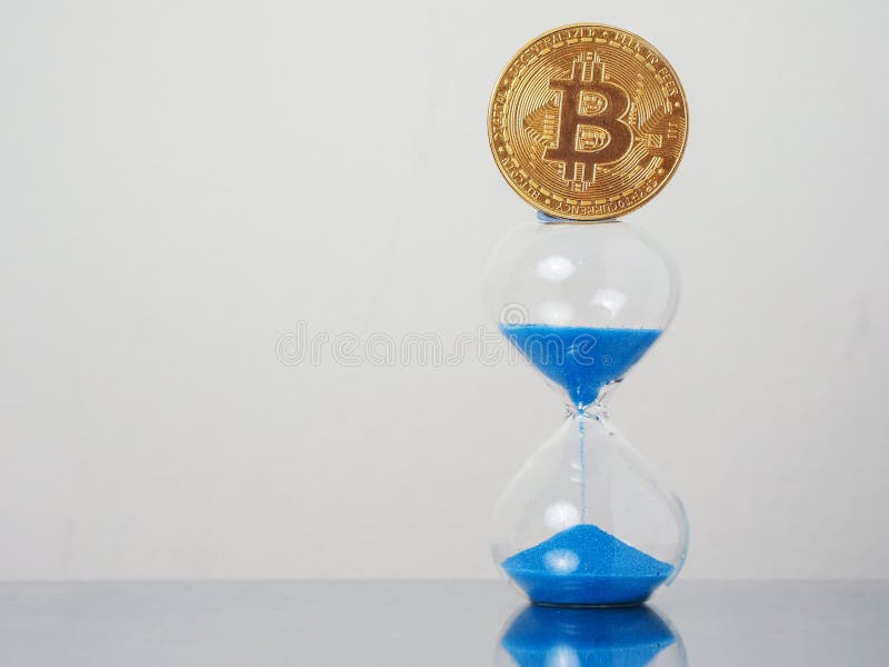 Golden bitcoin on blue sand clock. Time to invest into crypto currency concept. Economy and financial background royalty free stock images