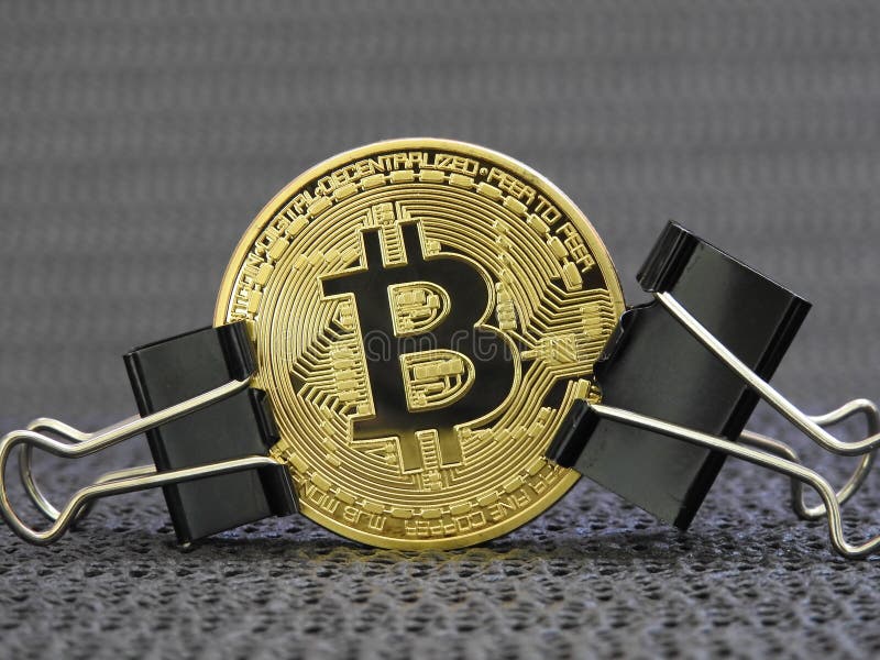Golden Bitcoin clamped stock photos