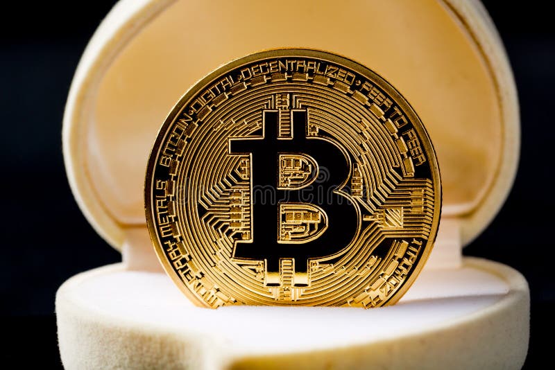 Golden Bitcoin coin in wedding ring box against black background. Close up image. Crypto currency electronic virtual money for web