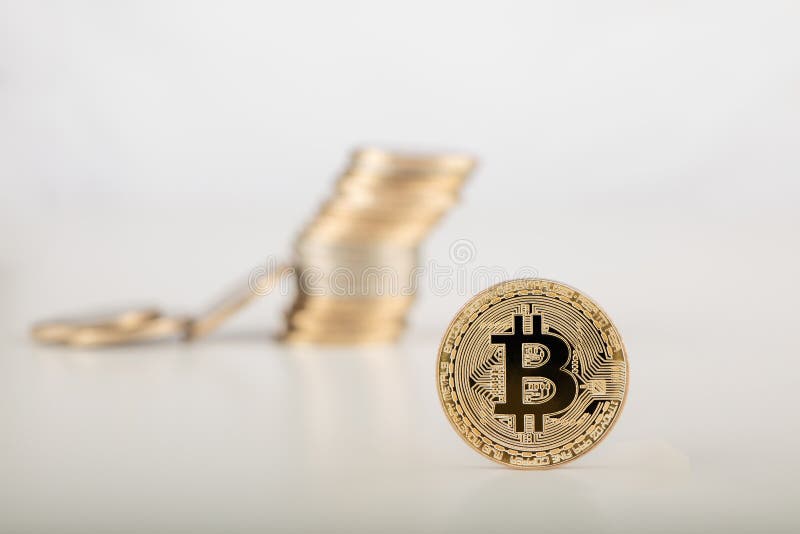 Stack of bitcoins with bitcoins background on gray surface