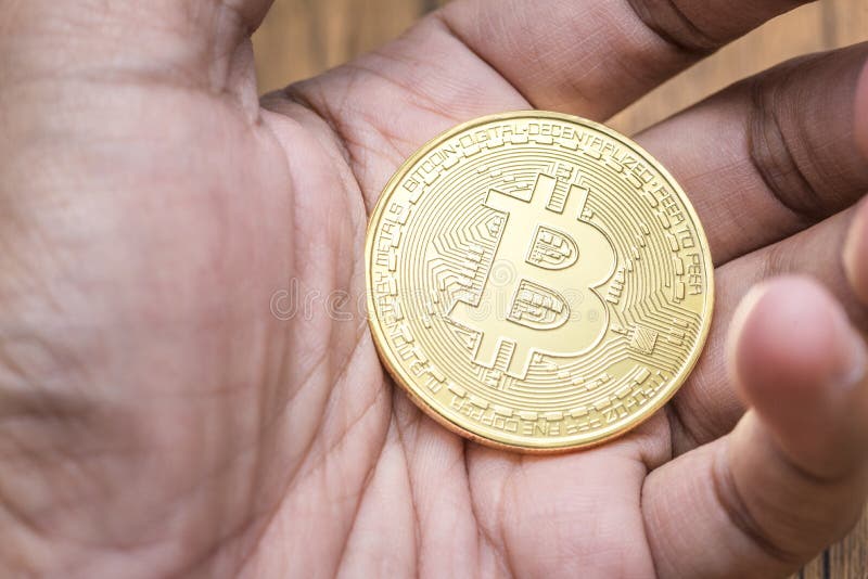 Golden bitcoin in the stock market investor hand for the digital money royalty free stock photography Golden bitcoin in the stock market investor hand for the digital money royalty free stock photography