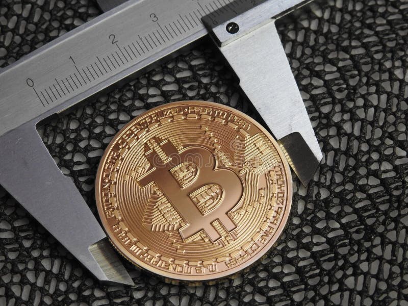 Golden Bitcoin and vernier caliper. stock photo