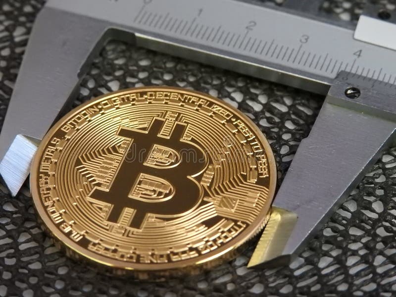 Golden Bitcoin and vernier caliper. royalty free stock photography