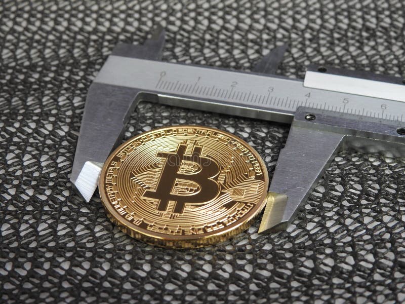 Golden Bitcoin and vernier caliper. stock images