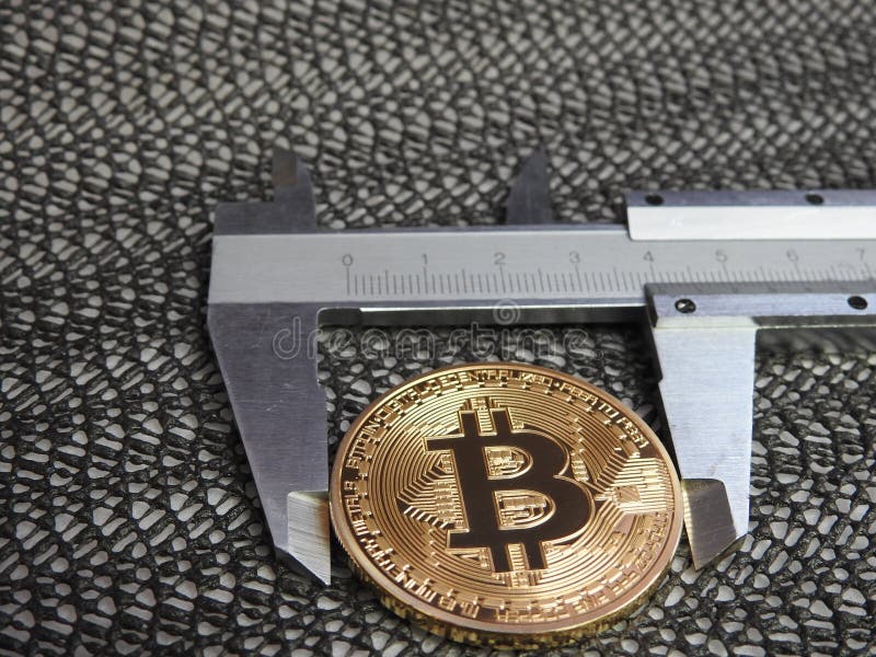 Golden Bitcoin and vernier caliper. stock photography