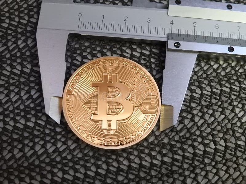 Golden Bitcoin and vernier caliper. royalty free stock photo