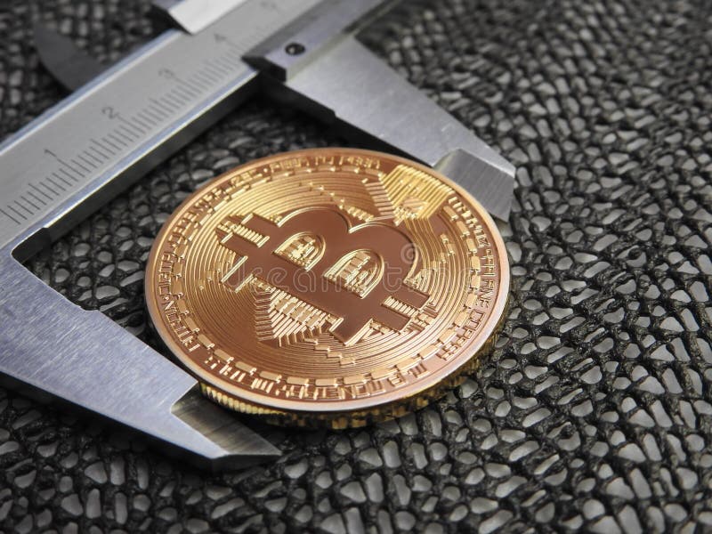 Golden Bitcoin and vernier caliper. royalty free stock photo