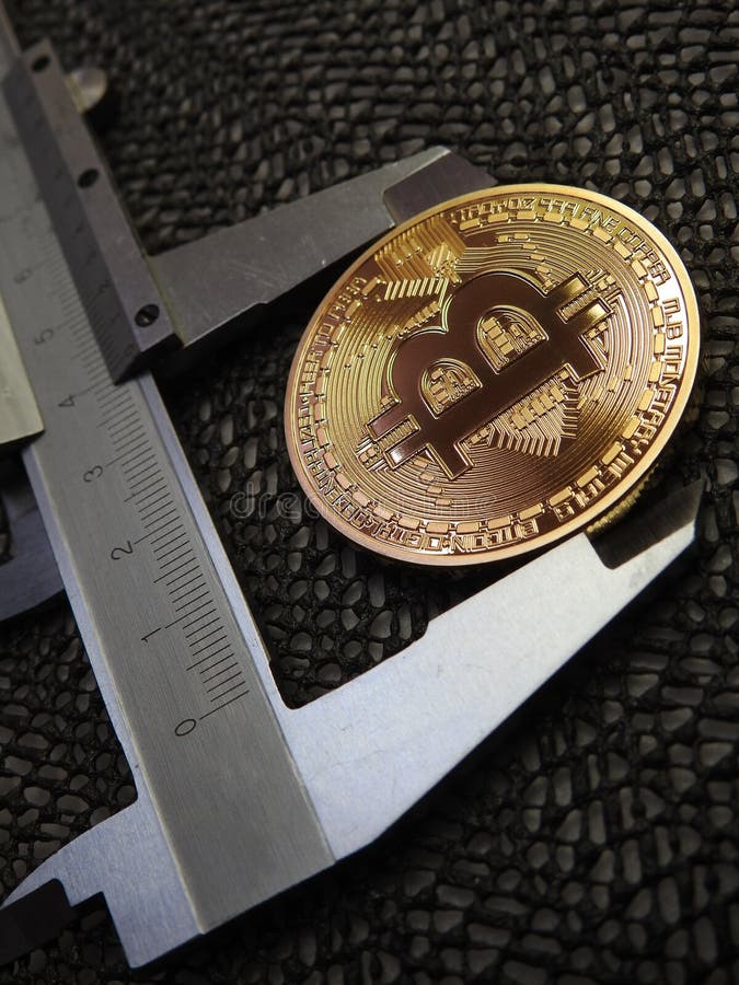 Golden Bitcoin and vernier caliper. royalty free stock images