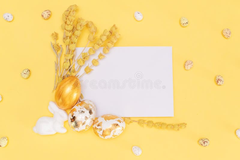 Golden chocolate Easter eggs and chocolate bunny with copy space on a yellow background