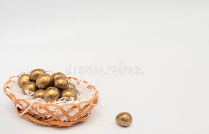 Golden chocolate Easter eggs in egg basket with white paper like a nest. Happy Easter holiday concept. Banner royalty free stock images