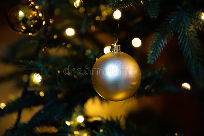 Golden decoration globe on christmas tree close up