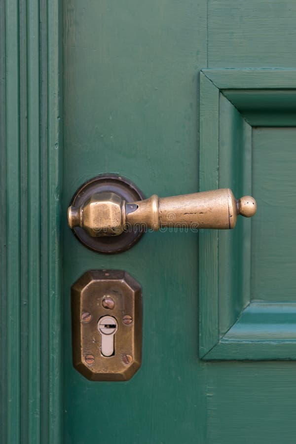 Golden door handles on green wooden doors. Old door handle royalty free stock image Golden door handles on green wooden doors. Old door handle royalty free stock image