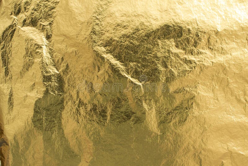 Golden foil pieces as texture, decorative wrapping paper royalty free stock image