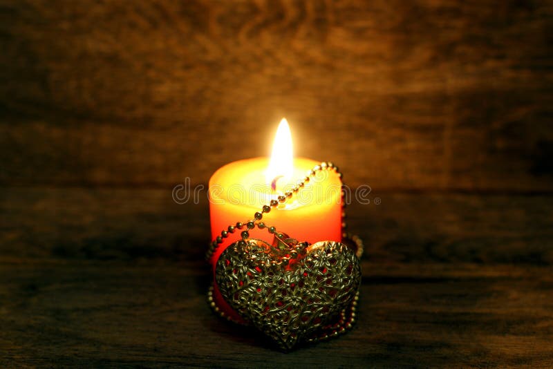 Golden heart and burning candle
