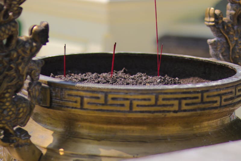 Golden Incense Burner with Red Burning Incense Sticks in the Buddhism
