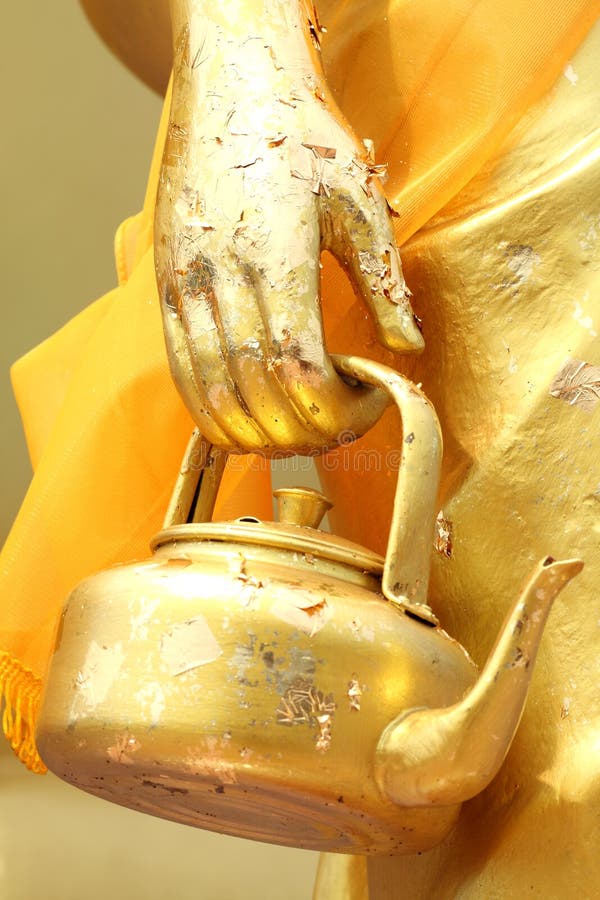 Golden Kettle in The Hand of Monk royalty free stock images