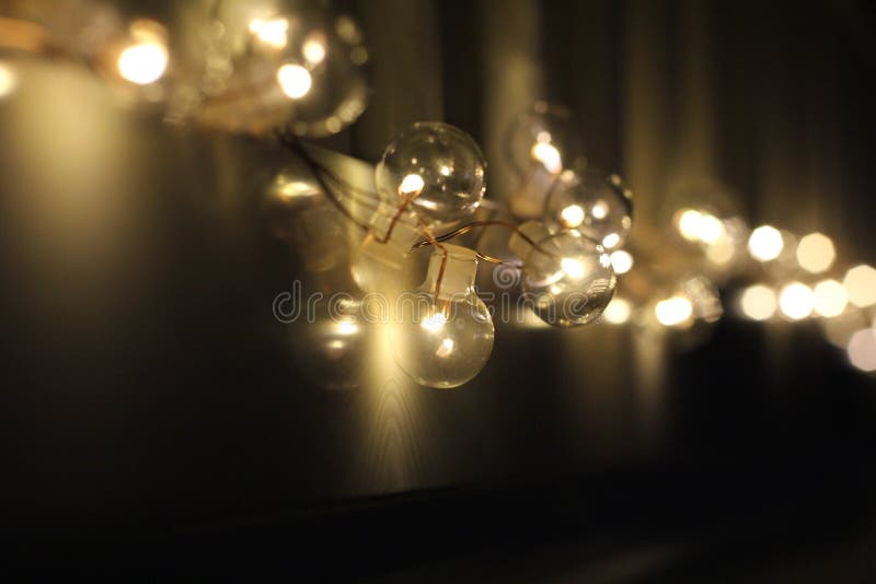 Golden light bulbs on the night dark background. City lights. Bokeh soft abstract background. Bokeh - Image stock photo Golden light bulbs on the night dark background. City lights. Bokeh soft abstract background. Bokeh - Image stock photo