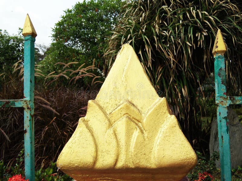 Golden lotus flower cement artificial between rusty blue steel poles stock images Golden lotus flower cement artificial between rusty blue steel poles stock images