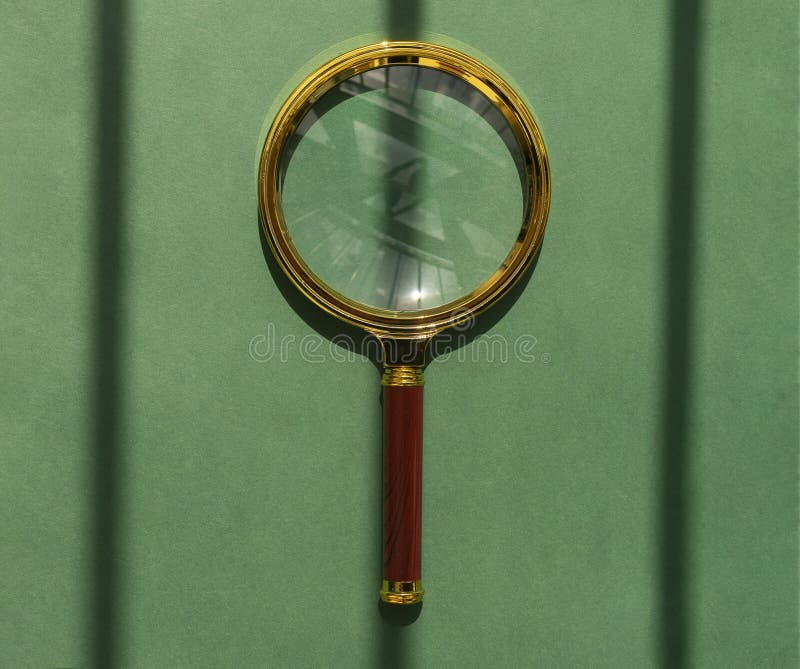 Golden magnifying glass over green shadow-striped background. Magnifier as concept of finding answers stock images