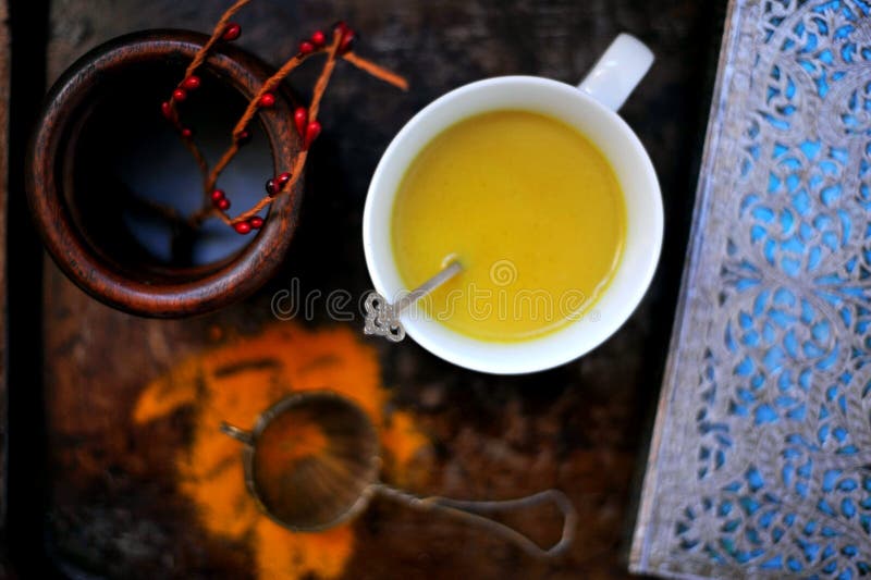 Golden milk, turmeric and almond milk with cinnamon and coconut oil used as healthy energy drink