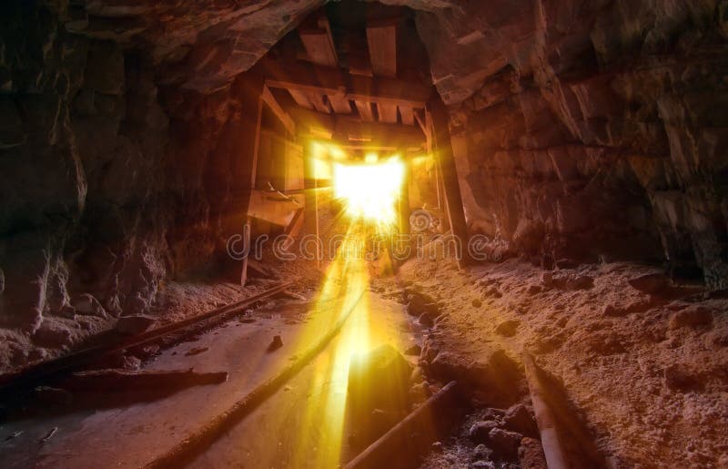 Inside an Abandoned Gold Mine with ore cart tracks and light streaming in. Inside an Abandoned Gold Mine with ore cart tracks and light streaming in