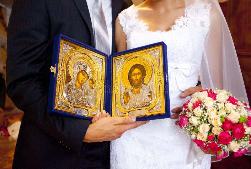 Golden Orthodox icons of The virgin and Jesus in hands of bride and groom royalty free stock images Golden Orthodox icons of The virgin and Jesus in hands of bride and groom royalty free stock images