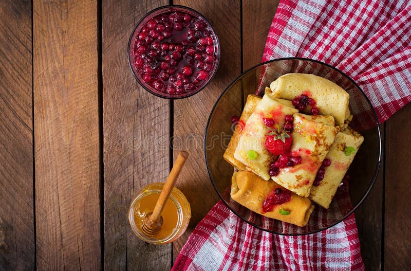 Golden pancakes with cranberry jam. Crepes, close.