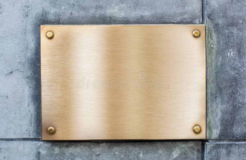 Golden plate or plaque made of bronze on wall royalty free stock photos
