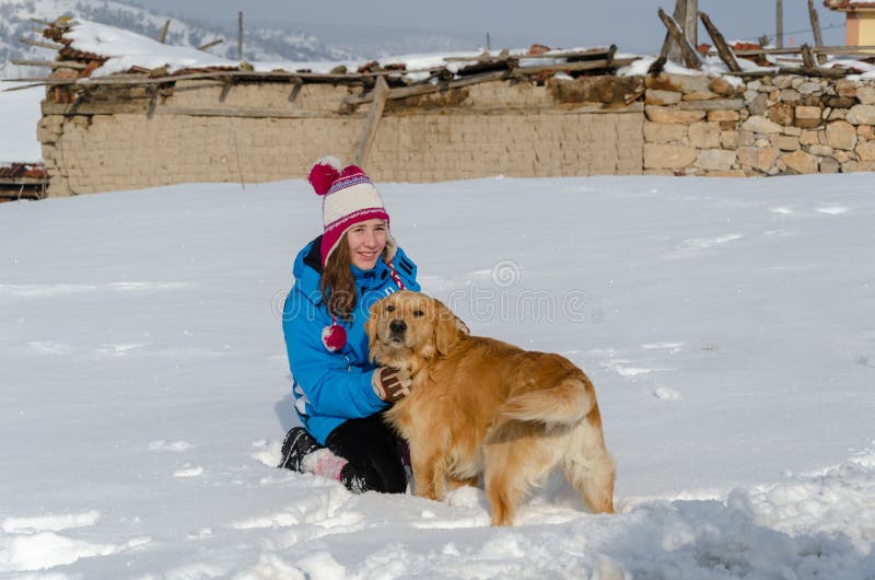 Golden retrieverhunden spelar med flickan på insnöad vinter royaltyfria foton Golden retrieverhunden spelar med flickan på insnöad vinter royaltyfria foton