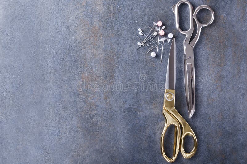 Top view of silver and golden scissors, sewing pins on rustic grey surace.Empty space for your design royalty free stock images Top view of silver and golden scissors, sewing pins on rustic grey surace.Empty space for your design royalty free stock images