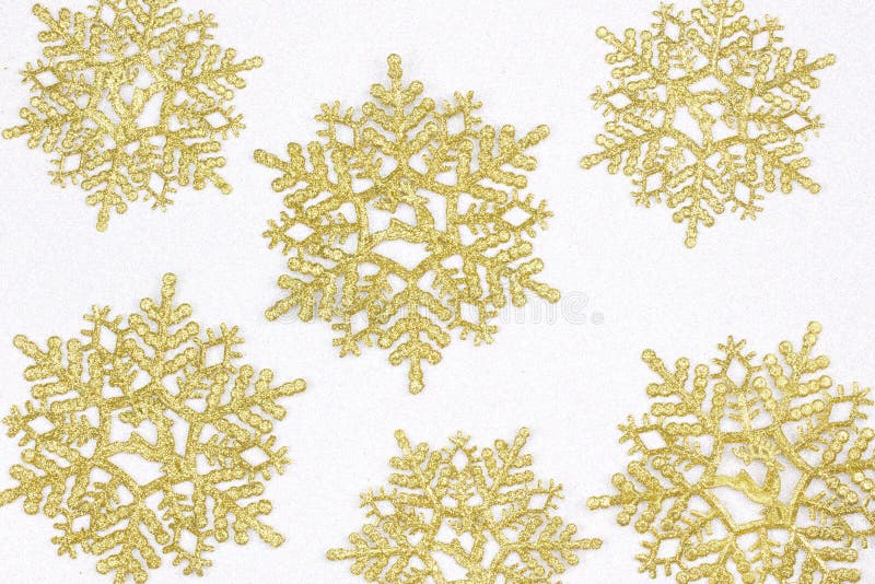 Golden snow flakes with glittering white background. Christmas t