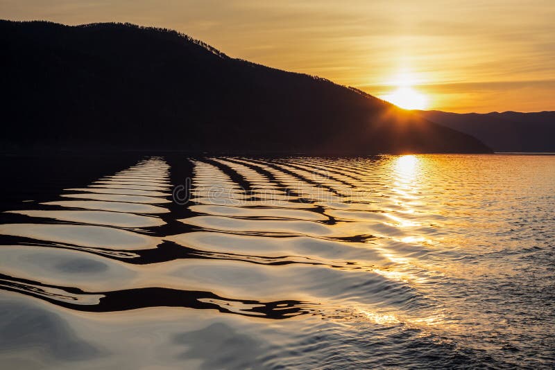 Golden soft waves at sunrise on the lake stock image Golden soft waves at sunrise on the lake stock image