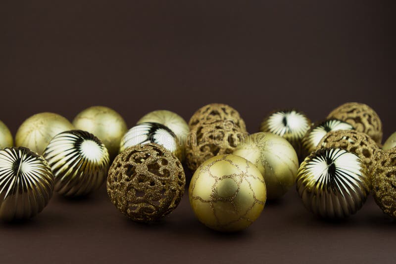 Golden sparkly Christmas balls on brown background. Magic holiday card. Christmas or New Year festive composition royalty free stock image Golden sparkly Christmas balls on brown background. Magic holiday card. Christmas or New Year festive composition royalty free stock image