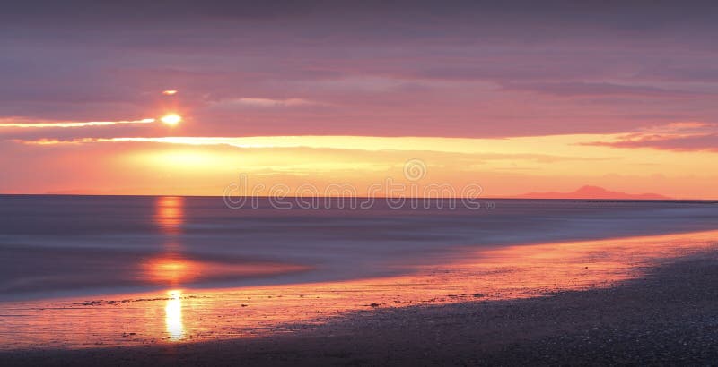 Zlatý západ slunce na pláži, Tywyn, Wales.