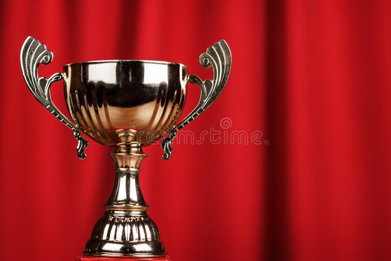 Golden trophy cup over red background royalty free stock image