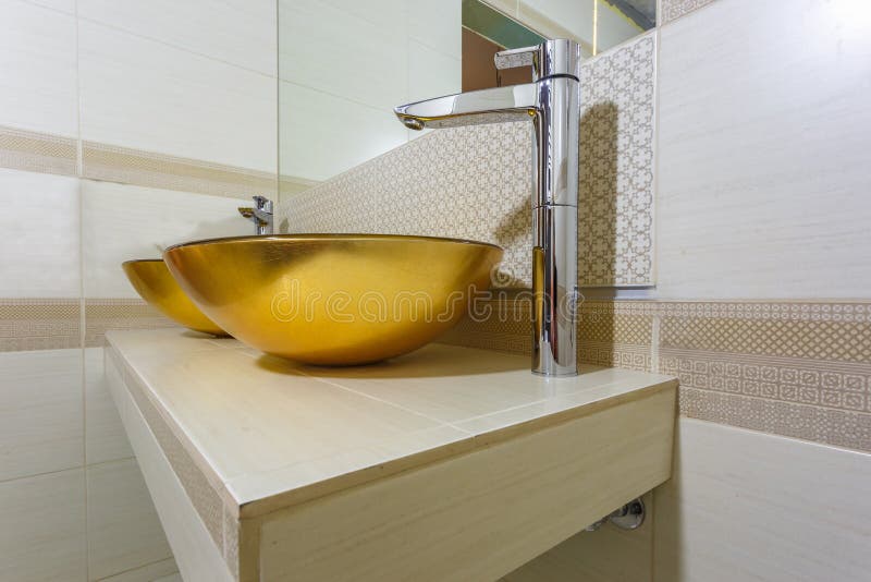 Golden Washbasin with Water Tap in Expensive Bathroom Stock Photo