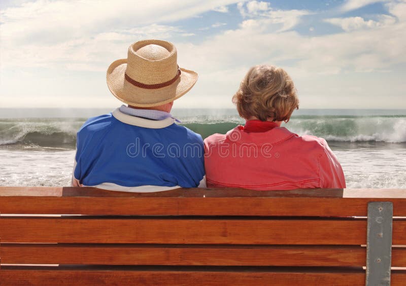 A senoir adult couple sitting at a benchand, enjoying their time at the beach. Happy embracing couple stock images, royalty-free photos and pictures