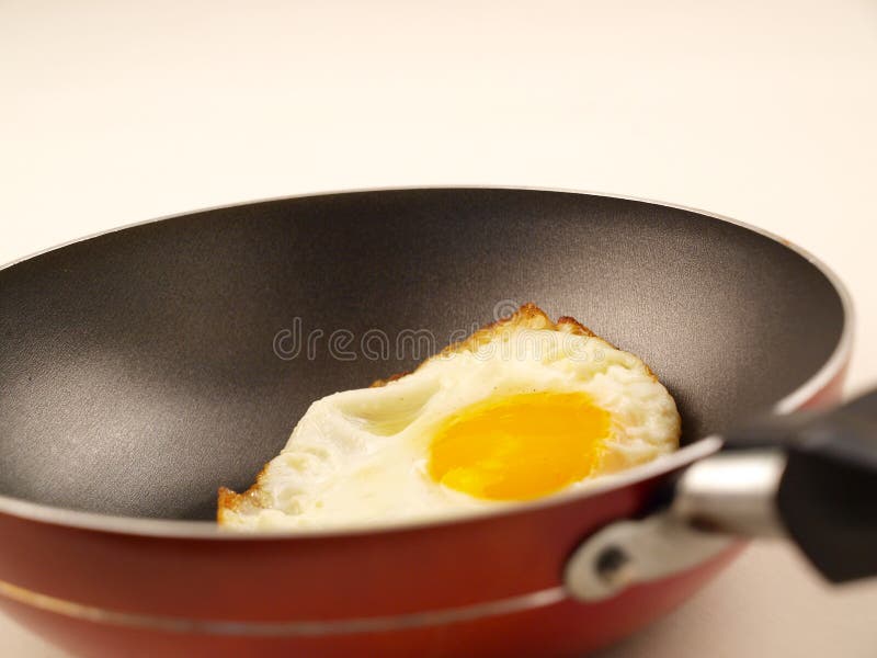 Golden Yolk Fried Egg in Red Non-Stick Frying Pan royalty free stock photos