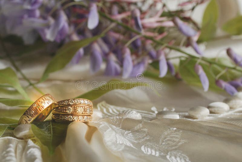 Goldene Ringe auf antikem Elfenbein-Hochzeits-Kleid stockbilder