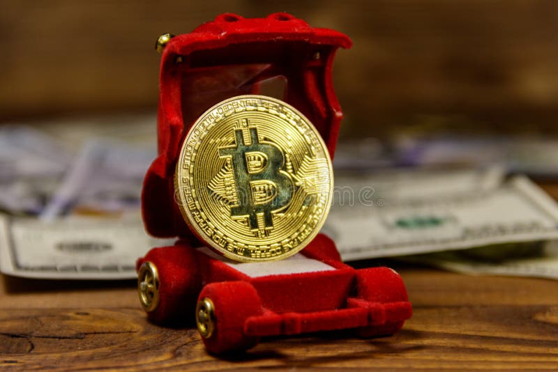 Goldenes Andenkenmünze bitcoin in der auto-förmigen Geschenkbox für Schmuck und Dollar auf hölzernem Hintergrund