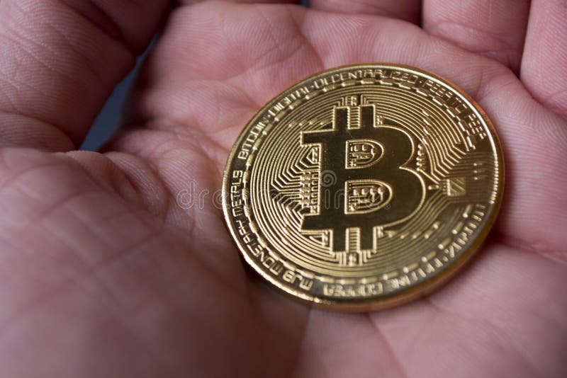 Goldenes bitcoin in der männlichen Hand