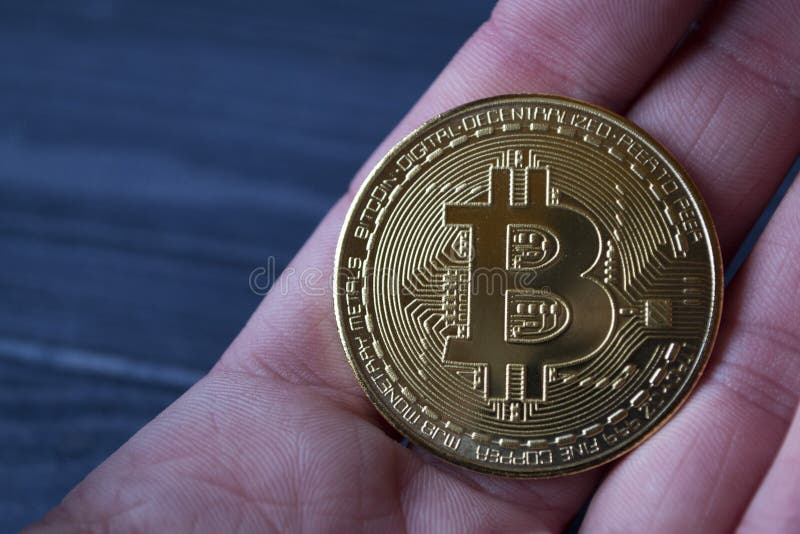 Goldenes bitcoin in der männlichen Hand