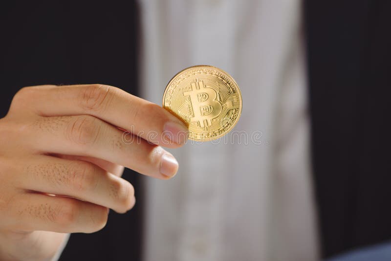 Goldenes Bitcoin in einer Geschäftsmannhand, Digitall-Symbol eines neuen v stockbild