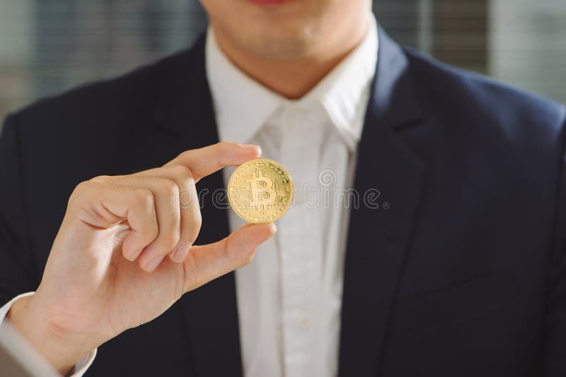 Goldenes Bitcoin in einer Geschäftsmannhand, Digitall-Symbol eines neuen v lizenzfreie stockbilder
